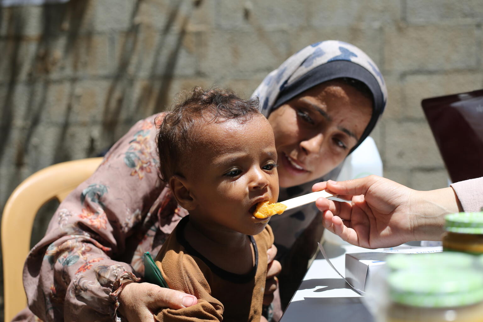 ガザ地区中部で、ユニセフが届けた栄養支援物資を口にする子ども（パレスチナ、2025年8月7日撮影）