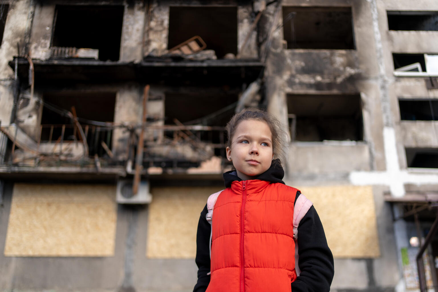 ミサイル攻撃で破壊された住宅の前に立つ、8歳のミロスラバさん（ウクライナ、2025年3月12日撮影）