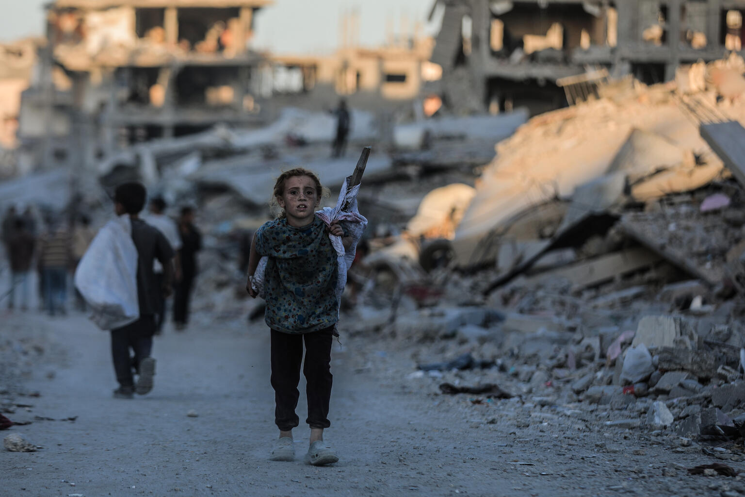 停戦の発表を受けて、ガザ北部へと戻ろうと、破壊された建物の間の道路を歩く子どもたちと家族(パレスチナ、2025年10月10日撮影)