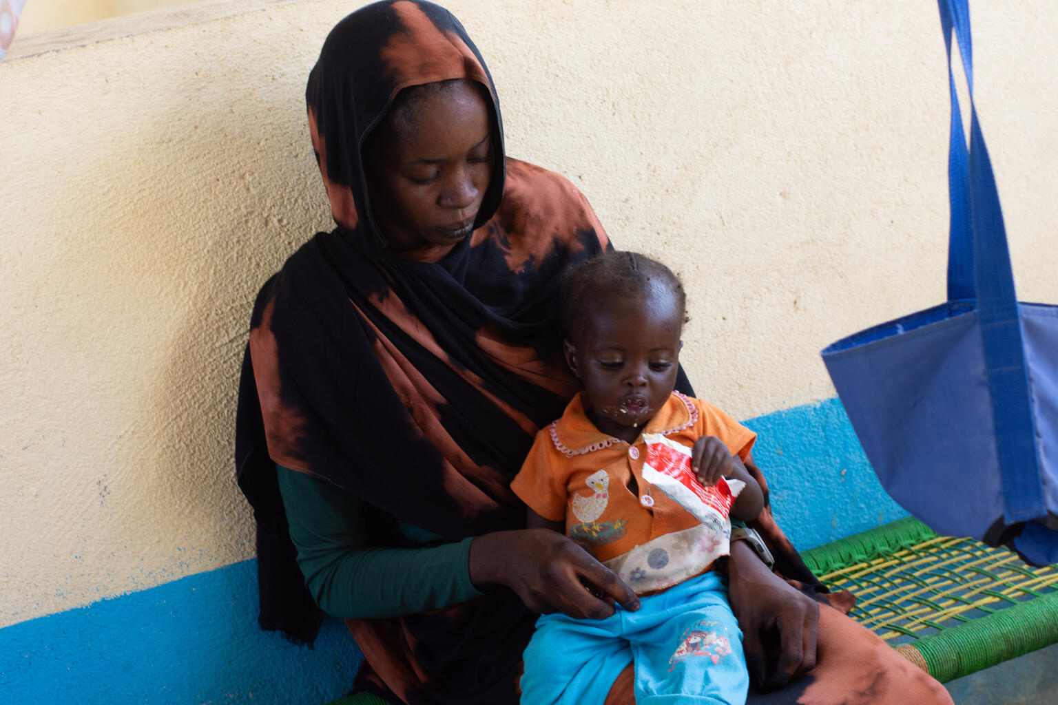 中央ダルフール州ザリンギの国内避難民キャンプで、ユニセフ支援物資の栄養治療食を口にする子ども（スーダン、2025年10月21日撮影）