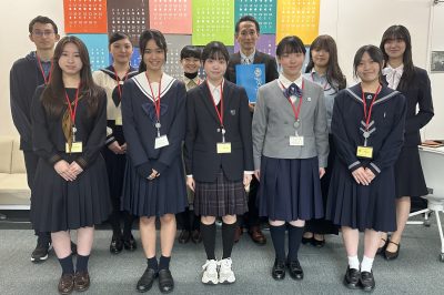 土居地球環境審議官と写真撮影をする高校生・大学生たち（東京・環境省、2025年11月5日撮影）