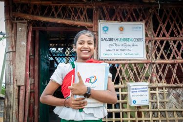 コックスバザールのロヒンギャ難民キャンプで、学習センターの前に立つ14歳のクルスムさん(仮名)(バングラデシュ、2025年8月31日撮影)