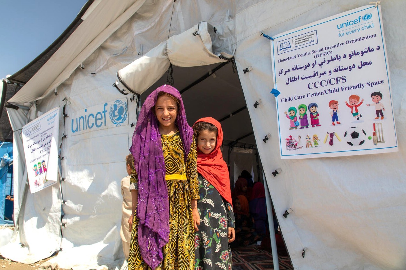 地震で被災したクナール県の避難民キャンプに設置されたユニセフの子どもにやさしい空間で笑顔を見せる、9歳と6歳の女の子たち（アフガニスタン、2025年9月9日撮影）