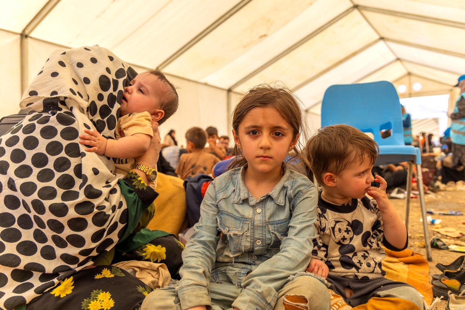 イランから帰還し、イスラムカラ国境に設置されたテントの中で母親と過ごす5歳のホザイマちゃん（右から二番目）と兄弟たち（アフガニスタン、2025年7月2日撮影）