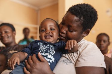 首都ルサカにある保健センターで、2歳のイアンちゃんを抱っこするリナさん。このセンターでは、無料のHIV検査やカウンセリング、母子感染防止のための支援を行っている（ザンビア、2025年3月19日撮影）