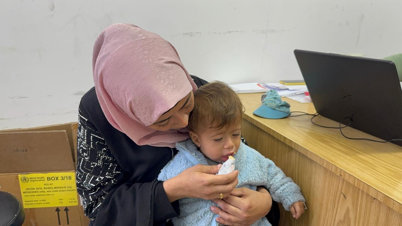 ガザ市にあるユニセフ支援の栄養治療拠点で、栄養治療食を食べさせてもらう生後11カ月のムアタズちゃん。栄養不良と診断されている（パレスチナ、2025年11月23日撮影）