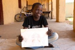 「マカンナ」での心のケアのセッションで描いた絵を見せるハーリドさん（スーダン、2025年9月23日撮影）