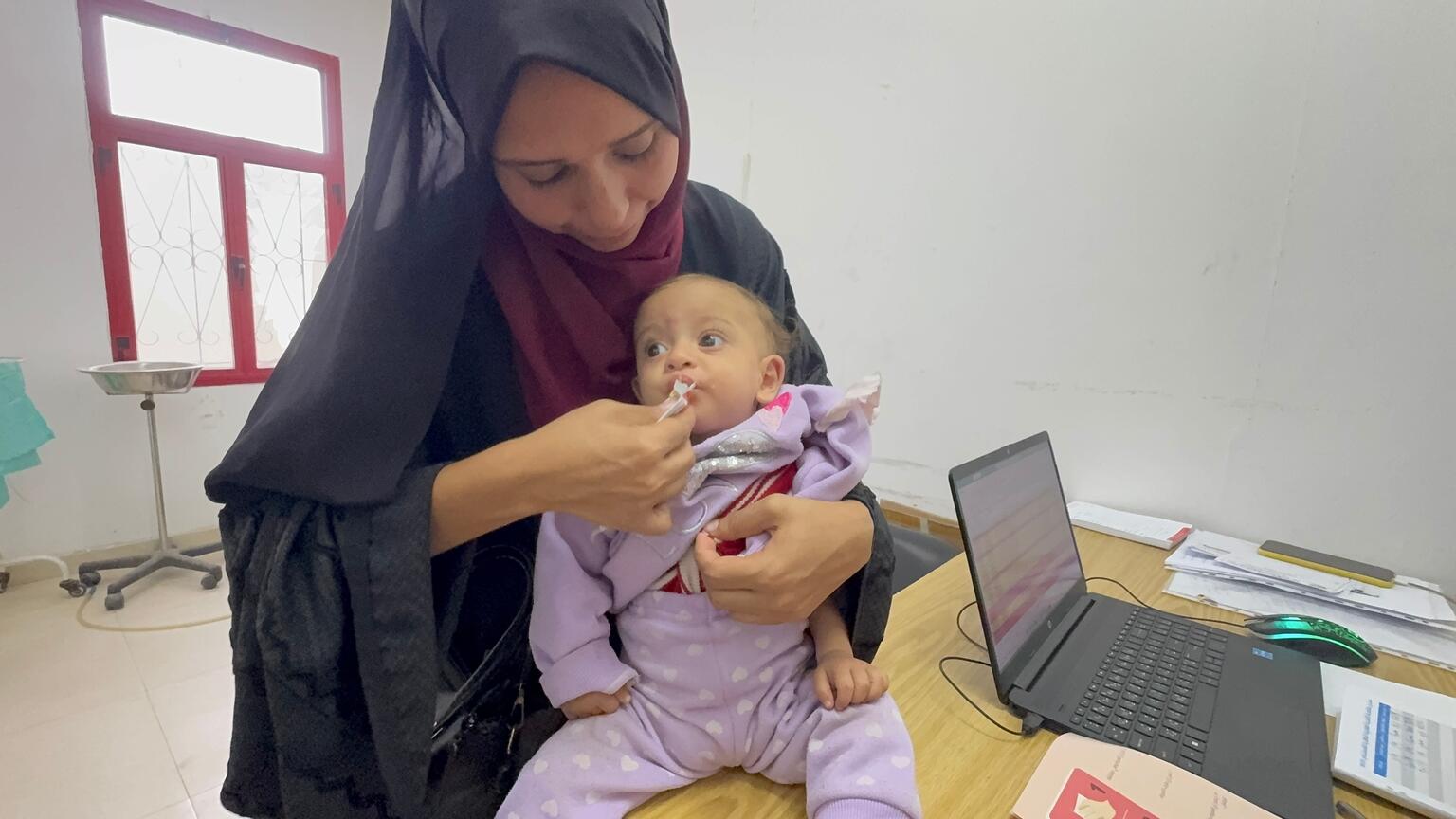 ユニセフ支援の栄養治療拠点で、栄養治療食を口にする生後10カ月のファラスティーンちゃん(パレスチナ、2025年11月23日撮影)