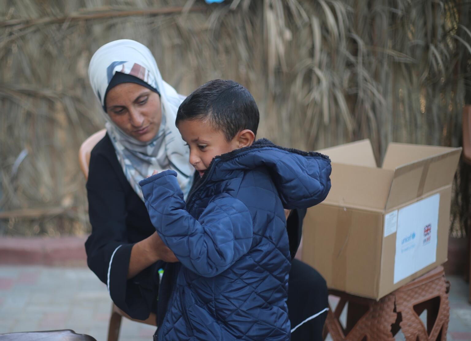 気温が下がり始めたデルバラハで、温かい上着を着せてもらう子ども。ユニセフは、ガザ地区全域で、子どもたちに防寒着を配布している（パレスチナ、2025年11月18日撮影）