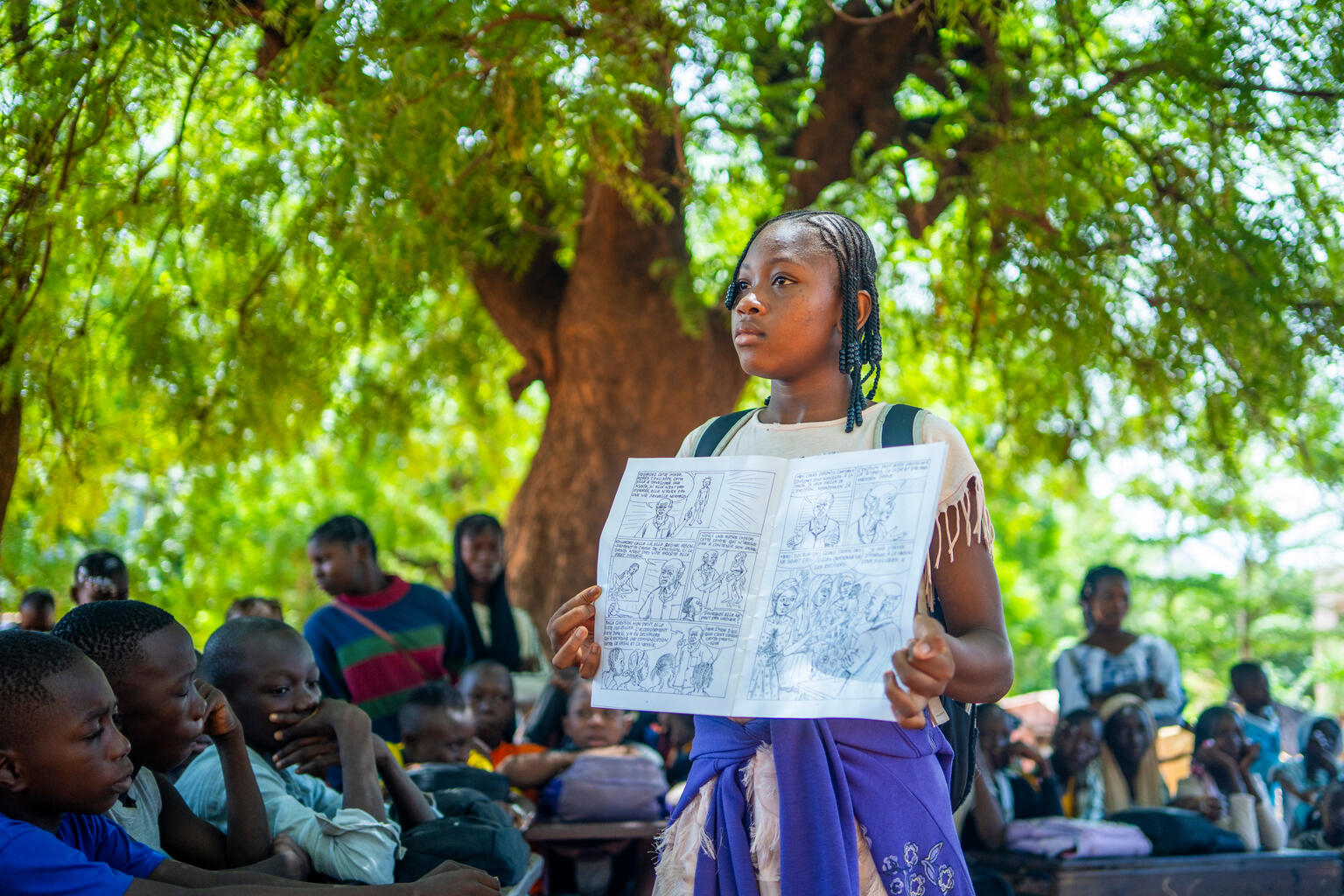 女性器切除（FGM）の有害な影響について、校庭で他の生徒に向けて説明する、中学3年生のアッサンさん（14歳）。