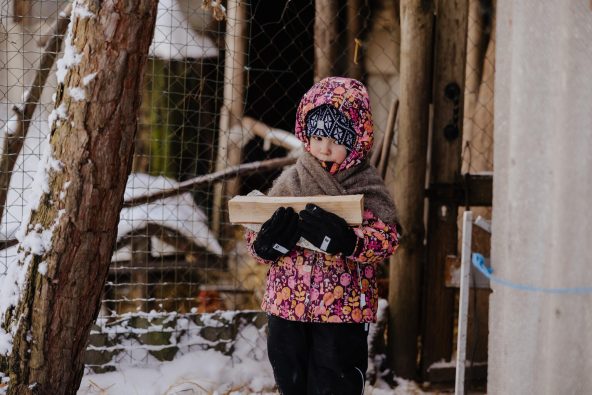 キーウへの攻撃で電気、暖房、水が使えなくなり、家族でキーウ州ミコライウカまで避難してきた4歳のアリカちゃん。氷点下18度の寒さの中、唯一の暖房器具である薪ストーブを使っている(ウクライナ、2026年1月18日撮影)