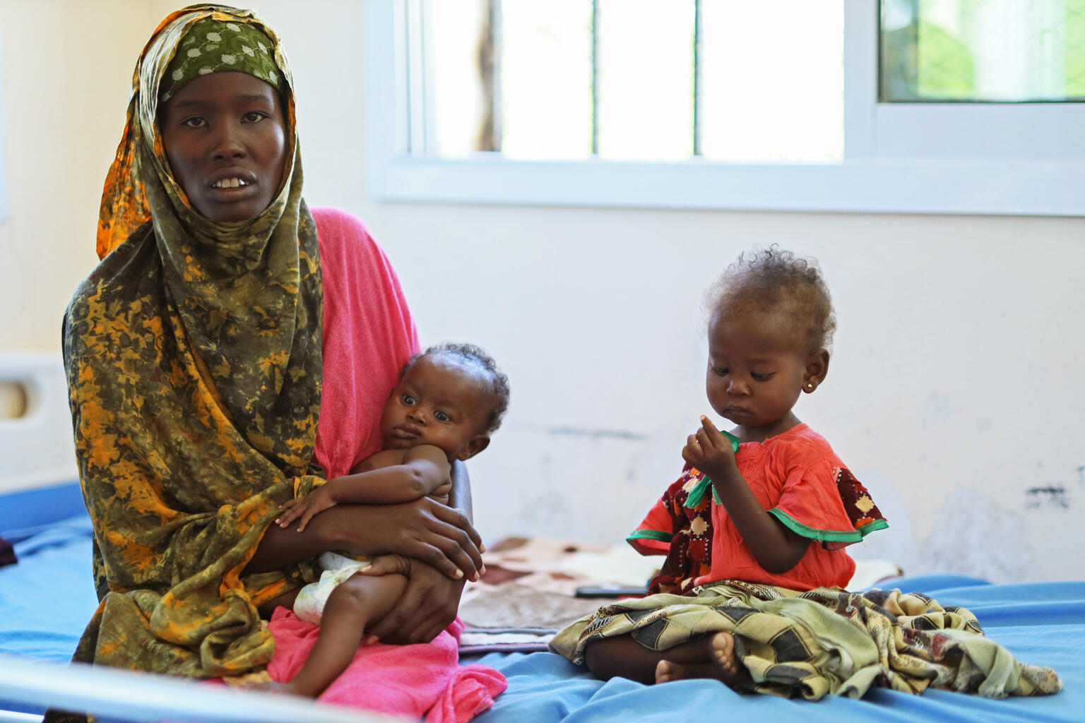 南部ドローの医療施設で重度の急性栄養不良と合併症の治療を受ける子どもたちと、付き添っている母親。干ばつによって、多くの人びとが生計手段である家畜と農作物を奪われた(ソマリア、2026年3月25日撮影)