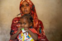 ジャジーラ州で、すぐに食べられる栄養治療食(RUTF)を口にする子ども（スーダン、2026年3月16日撮影）