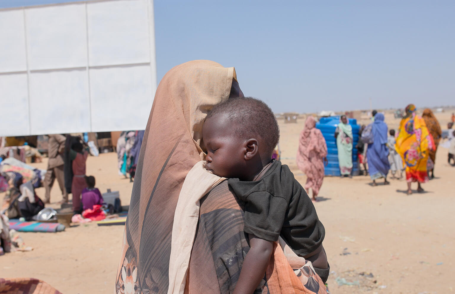 南コルドファン州カドクリから、白ナイル州のゴズ・アルサラーム国内避難民キャンプまで逃れてきた親子。母親のハリマさんは、7人の子どもを連れて、21日間歩きたどり着いたという（スーダン、2026年2月15日撮影）