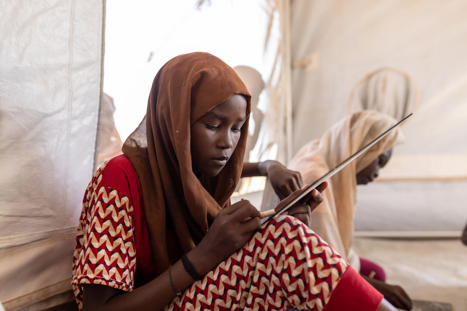 白ナイル州の避難民キャンプで、ユニセフが支援する「子どもにやさしい空間」で絵を描く13歳のヌーハさん。コルドファンから逃れてきたが、混乱の中で家族と離れ離れになり、現在もその行方は分かっていない（スーダン、2026年2月15日撮影）