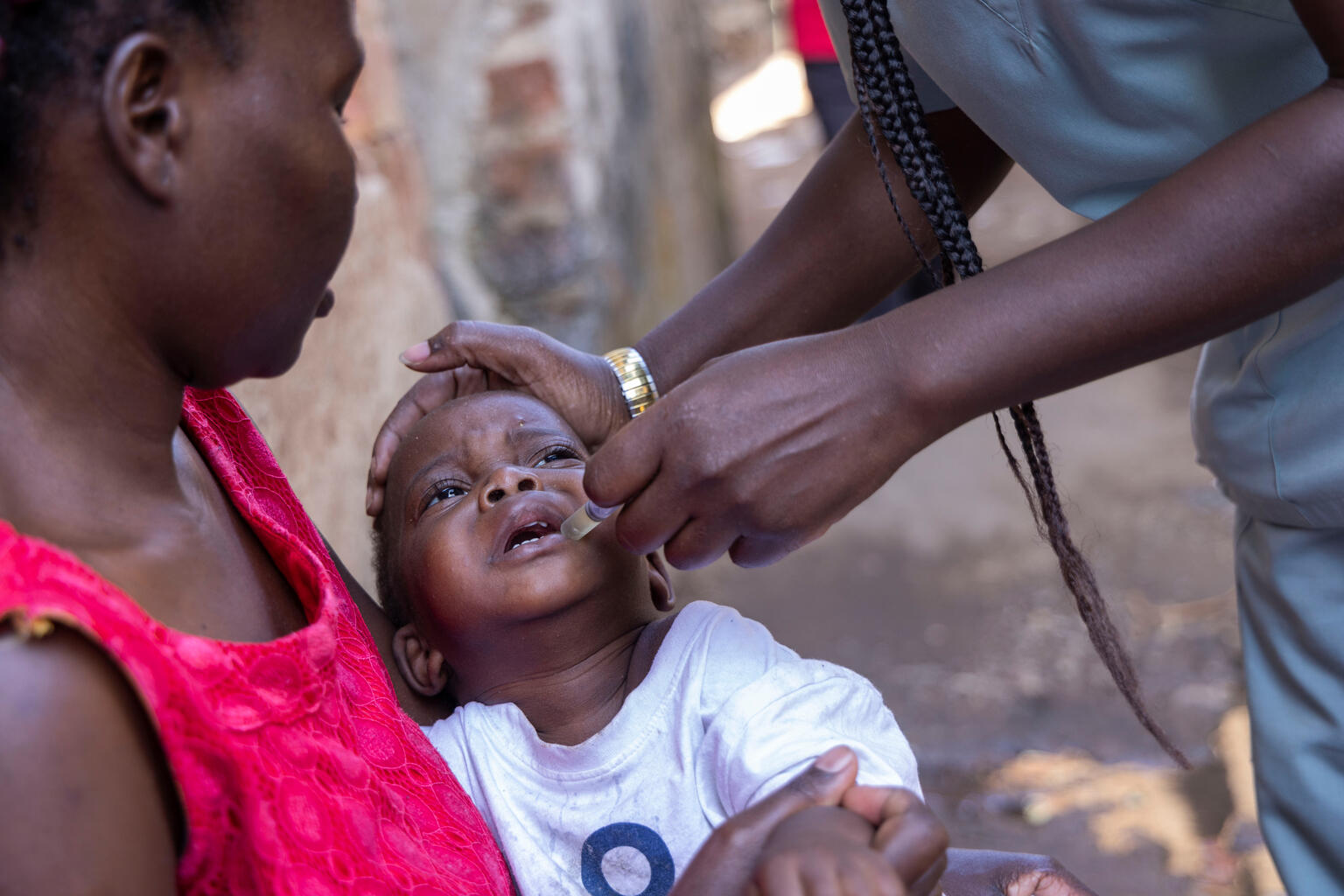 生まれて初めての予防接種を受ける1歳のエルビスちゃん。ユニセフは、戸別訪問による予防接種を支援している（ウガンダ、2025年11月27日撮影）