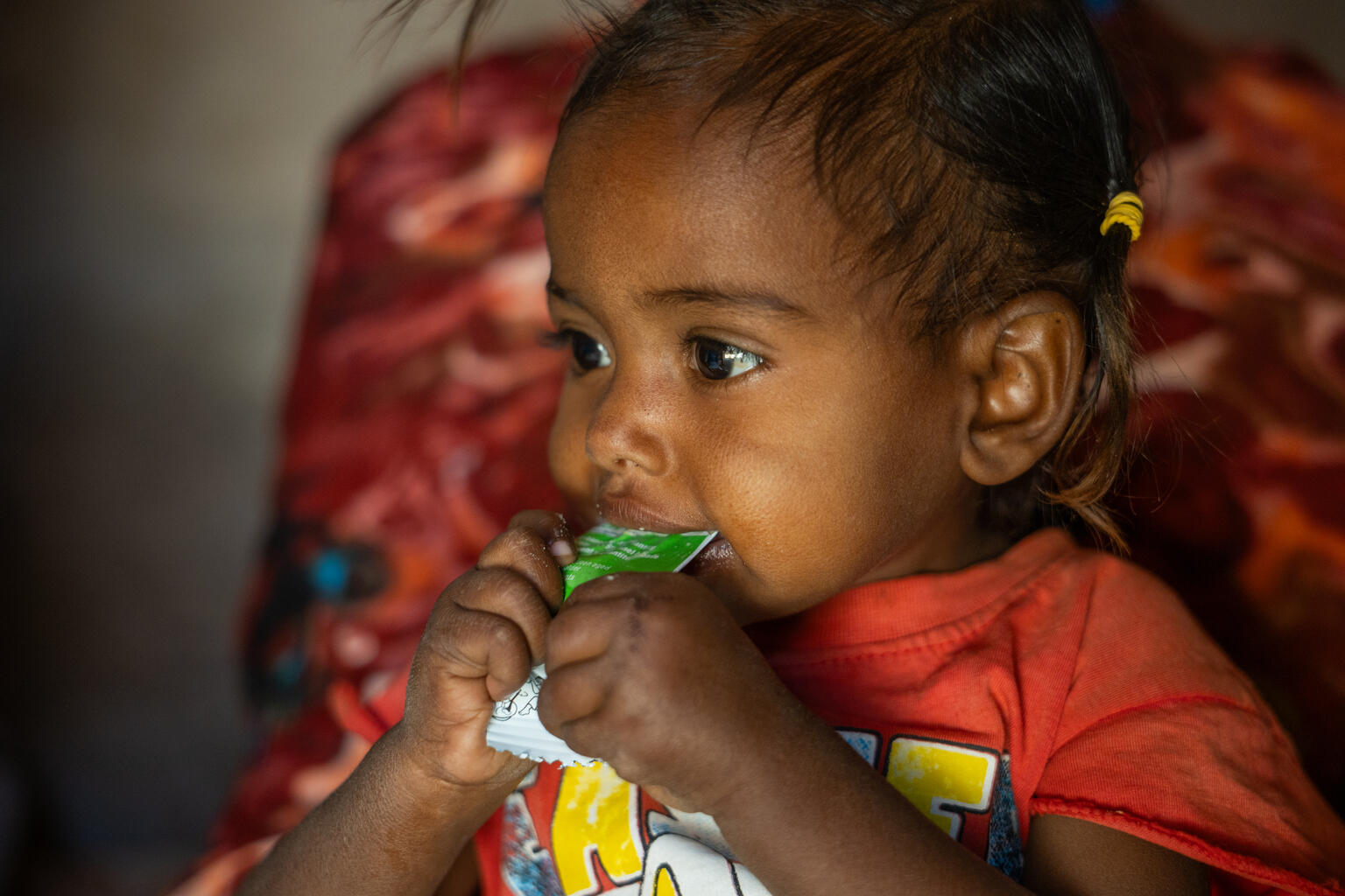 ジャジーラ州で、すぐに食べられる栄養治療食（RUTF）を口にする子ども。ユニセフの支援のもと、地域保健員が戸別訪問を行い、栄養不良の子どもを早期に発見して治療につなげている（スーダン、2026年3月16日撮影）