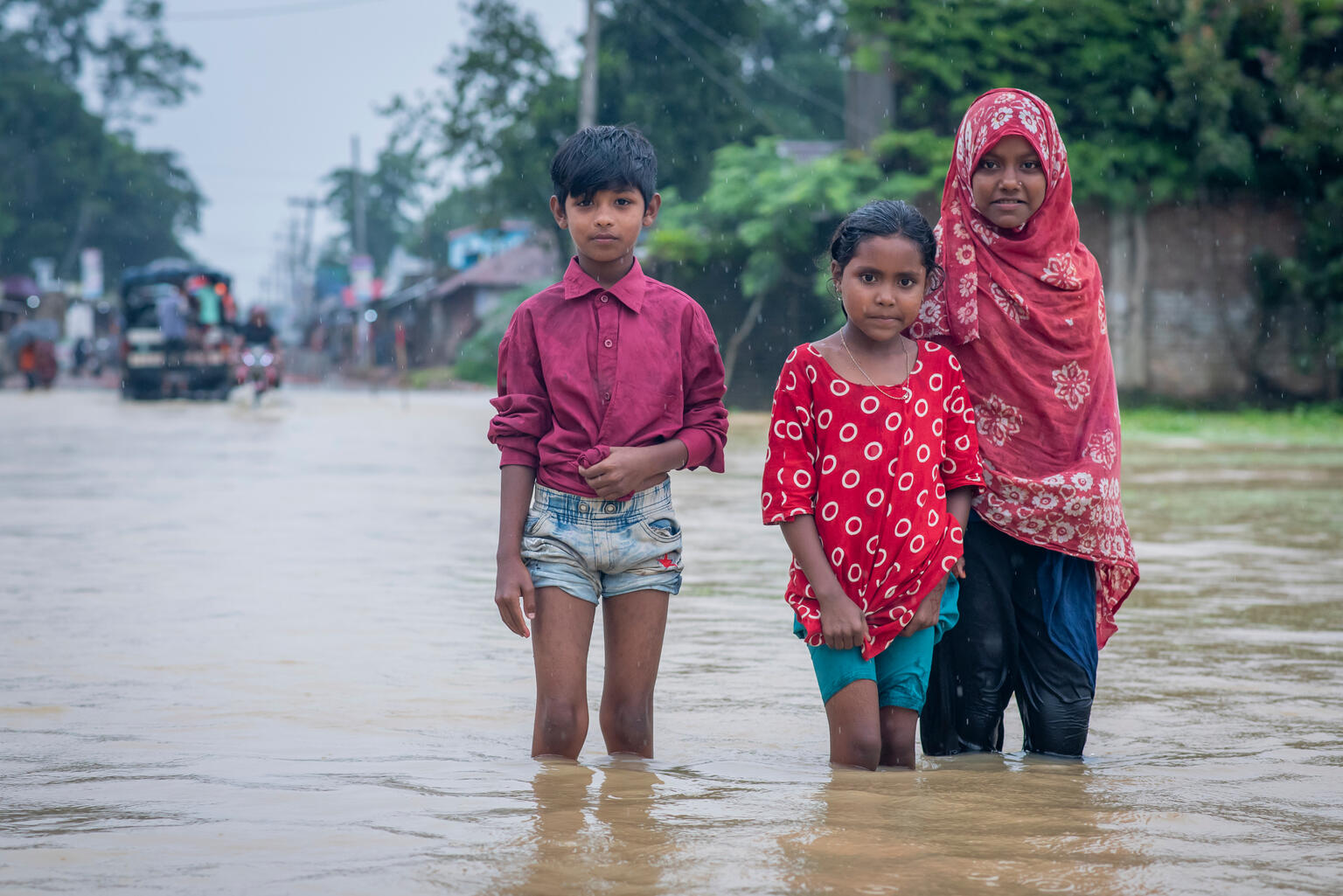 サイクロンによる洪水で浸水した道路を歩く子どもたち（バングラデシュ、2025年7月10日撮影）