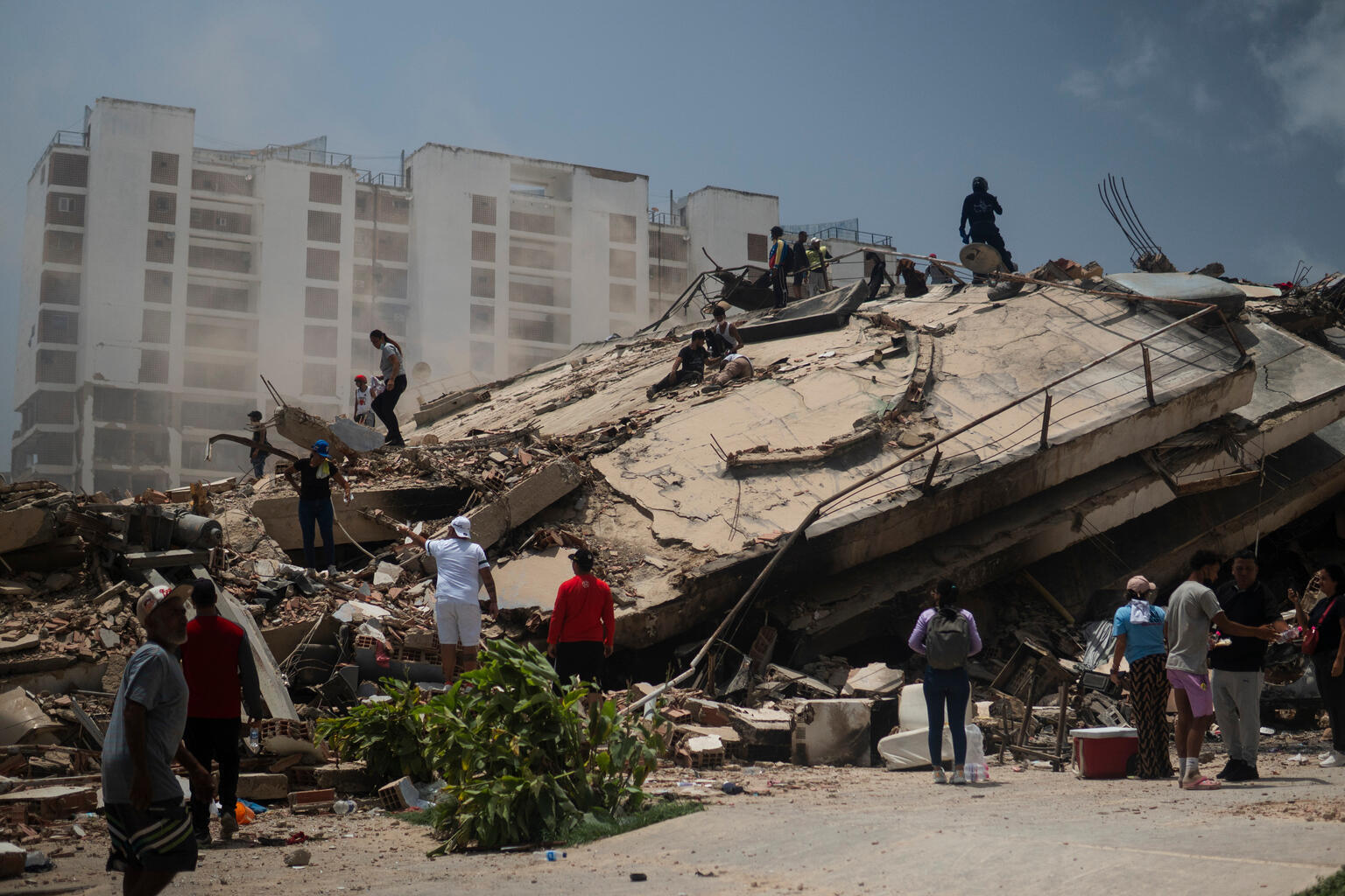 地震により、多くの建物が倒壊したラ・グアイラ州で、がれきの中に取り残された人々を捜索する様子（ベネズエラ、2026年6月27日撮影）
