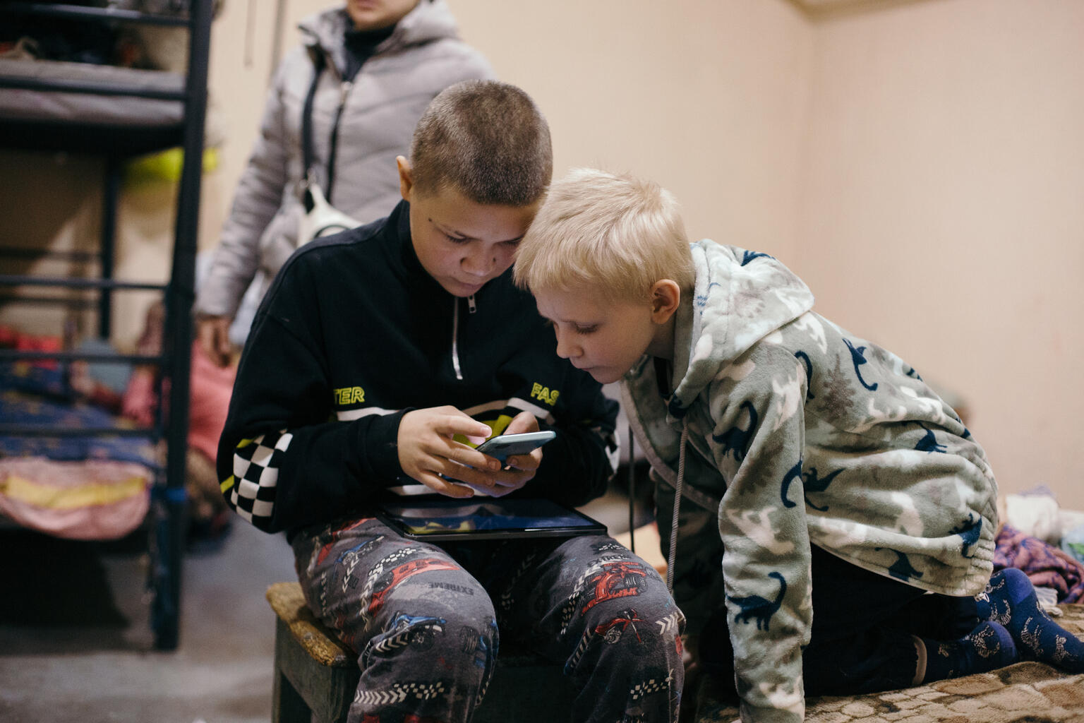砲撃が続くヘルソン州の地下シェルターで、スマートフォンに見入る子どもたち（ウクライナ、2026年3月11日撮影）