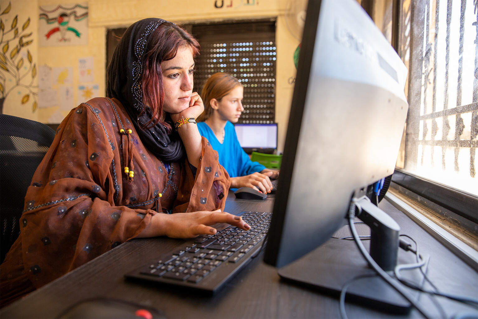 ユニセフが支援する学習センターで、コンピューターを使って勉強する14歳のダマアさん（ヨルダン、2025年5月21日撮影）