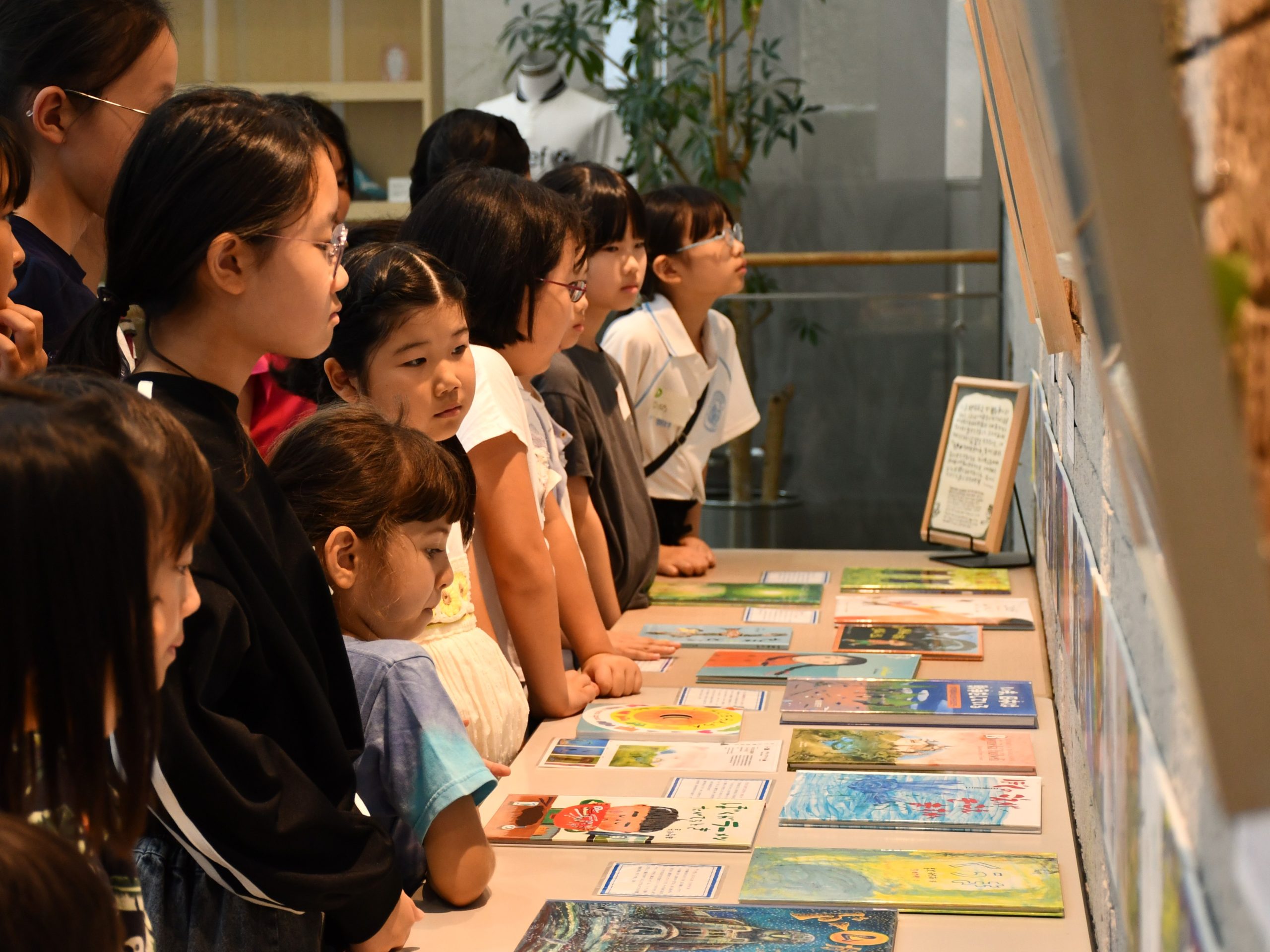 絵本作家の石川えりこさんの解説を聞きながら、『ちきゅうパスポート』の原画に真剣な表情で見入る参加者たち