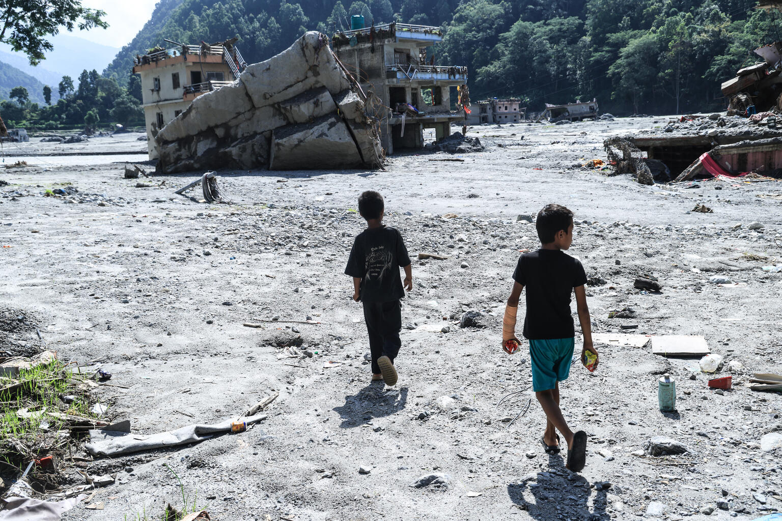 ヌワコットで、土石流により壊滅的な被害を受けた学校の跡地を歩く子どもたち（ネパール、2026年9月9日撮影）