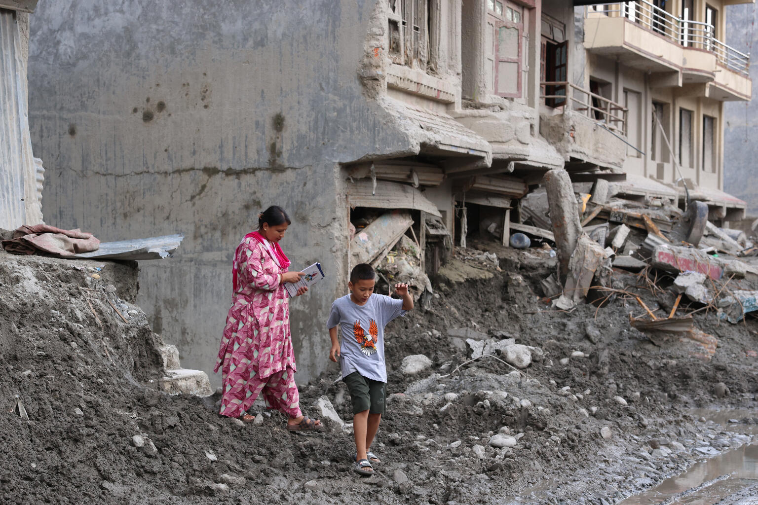 ヌワコット郡の土石流被災地で、失われた持ち物を探す10歳のスワスティクさんと母親のサイラジャさん(ネパール、2026年9月21日撮影)