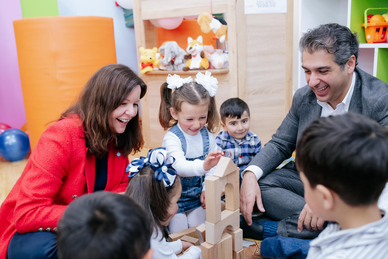 ユニセフが開設した就学前教育施設で、子どもたちと遊ぶスムバティアン氏(右)。左はクリスティン・ヴァイガント ユニセフ・アルメニア事務所代表(2023年5月、アルメニア・シラク地方)