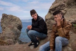 アリ・アブドゥル・ハリムくん(17)はギリシャのレスボス島のスカラ・エレソス村の海辺で携帯電話で話す弟のアーメッドくん（15）を見つめる。