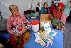 ユニセフが支援する母親のための避難所で、受け取った家族用の衛生キットを見せる母親。