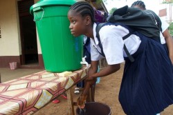 エボラ予防のため、教室に入る前に手を洗う女の子（2015年3月撮影）。