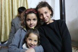 自宅で笑顔を見せるガイターさんやイスラーさん、アイシャさん。紛争で父親を失った姉妹は、ユニセフが支援するセンターの「子どもにやさしい空間」で一時の心の安らぎを得ている。