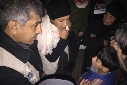 ユニセフ・シリア事務所 代表のハナア・シンガー（中央）が、住んでいた町が包囲された際に両親と離れ離れになってしまった10歳の男の子と話している。