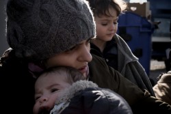 セルビアの国境付近で1カ月の息子をあやす母親。（マケドニア旧ユーゴスラビア共和国）