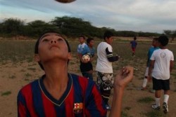 ユニセフのロゴが入ったFCバルセロナのユニフォームを着てサッカーをする男の子。