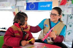 ユニセフの「子どもにやさしい空間」で笑顔で工作をする難民の女の子。（マケドニア旧ユーゴスラビア共和国）
