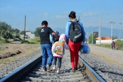 線路伝いに歩き続ける移民の家族