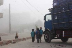 朝靄のなか、支援物資の提供を終えたトラックの横を通って学校へと向かうモアダミエの子どもたち。
