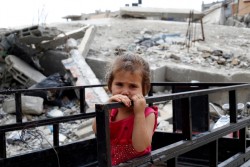 破壊された自宅の手すりに寄りかかる女の子。（パレスチナ）