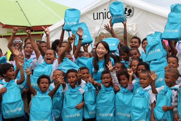 オバラウ島ロレト小学校 ユニセフの支援で設置されたテント造りの仮設教室の前で、子どもたちと。 ユニセフは、学用品がセットになったスクールバッグも配布した。