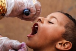 ポリオの予防接種を受ける男の子。（イラク）
