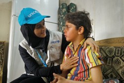 8歳のモハメドくんと話をするユニセフのスタッフ。2016年1月には栄養不良に陥っていた。栄養治療食で治療ケアを受け、現在は学校に通えるほどにまで回復した。