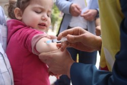 4月25日、予防接種キャンペーンで移動保健チームから予防接種を受けるアレッポの子ども。