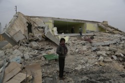 A child standing in front of his ground-flattened school after an bombardment in Ainjara village in rural Aleppo  on 11 January 2016. More than 20 children died or were injured as a result of an attack in the area. In Syria, one in four schools are damaged, destroyed or occupied for military purposes or to host displaced families.  An estimated over two million children are out of school.