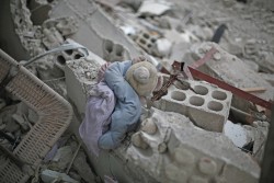シリアの破壊された建物のがれきの間に挟まれた、子どものおもちゃ。 ※本文との直接の関係はありません。