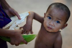 ラオスでココナッツを食べる子ども（2015年3月撮影）