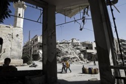 破壊されたビルや瓦礫の間を通って学校に向かう男の子たち。（シリア・イドリブ州　2016年9月撮影）※本文との直接の関係はありません。