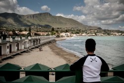 同伴者のいない子どもたちのための受け入れ施設で暮らしている男の子が、海岸を見下ろしている。（イタリア・シチリア2016年5月撮影）