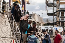 イタリア・シチリア島の港に到着し、スペインの沿岸警備隊の船から下りる、難民・移民の人々。（2016年5月撮影）
